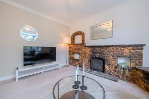 a living room with a fireplace and a tv at Over Lane in Almondsbury