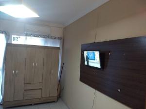 a room with a tv on a wall next to a door at Ponta Verde CENTRAL in Maceió