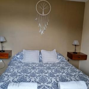 Schlafzimmer mit einem Bett mit einer blauen und weißen Bettdecke in der Unterkunft Casa en Playa Perelli in Villa Carlos Paz