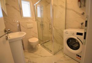 ein Badezimmer mit Toilette, Waschbecken und Waschmaschine in der Unterkunft House Branka in Vir