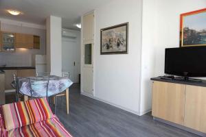 a living room with a table and a flat screen tv at Apartment in Porto Santa Margherita 48301 in Porto Santa Margherita di Caorle