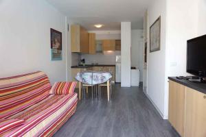 a living room with a couch and a table and a kitchen at Apartment in Porto Santa Margherita 48301 in Porto Santa Margherita di Caorle
