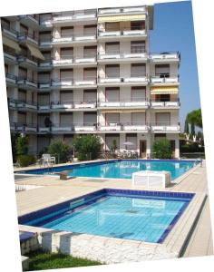a hotel with a swimming pool in front of a building at Apartment in Porto Santa Margherita 48301 in Porto Santa Margherita di Caorle +3 photos