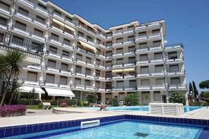 a hotel with a swimming pool in front of a building at Apartment in Porto Santa Margherita 48301 in Porto Santa Margherita di Caorle
