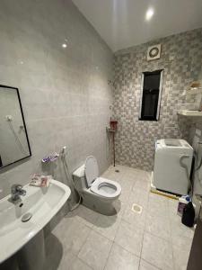 a bathroom with a toilet and a sink at قصر الريان in Buraymān
