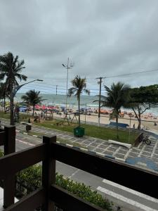 Una vista de una playa con palmeras y el océano. en Quarto beira mar - tombo - guarujá, en Guarujá