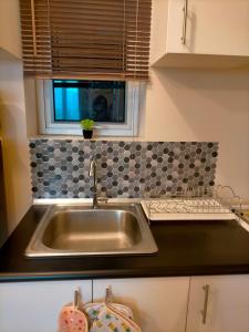 a stainless steel sink in a kitchen with a window at Sunset Suite in Iloilo City