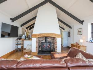 ein Wohnzimmer mit Sofa und Kamin in der Unterkunft Tai Ffolt in Pwllheli