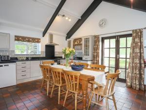 eine Küche mit einem Tisch und Stühlen in einer Küche in der Unterkunft Tai Ffolt in Pwllheli