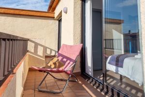 a pink chair sitting on a balcony with a bed at Molí del Mar in L'Escala +18 photos