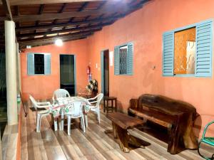 a room with a table and chairs and a bench at Rancho Do Claudim in Pirenópolis