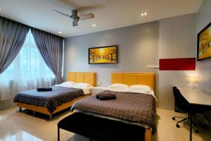 a bedroom with two beds and a desk in it at Kuching Cozy comfort RDA1608C - Riverine Diamond 4 pax in Kuching +13 photos