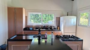 a kitchen with a sink and a refrigerator at Chalé Bela Vista in Torres +25 photos