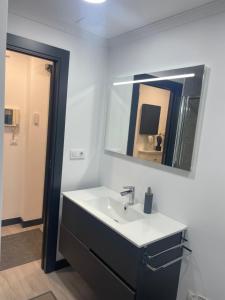 a bathroom with a sink and a mirror at El rincón de Cangas in Cangas de Morrazo +19 photos