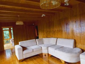 a living room with a white couch and wooden walls at Private House Next to the Cloud Forest Reserve in Monteverde Costa Rica