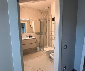 a bathroom with a shower and a toilet and a sink at Habitare Elegantiae - Home Cinema - Air Conditioning - Historic center in Trento