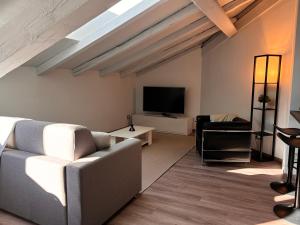 a living room with a couch and a flat screen tv at Habitare Elegantiae - Home Cinema - Air Conditioning - Historic center in Trento