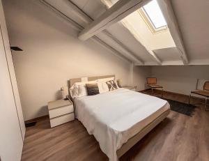 a bedroom with a large bed and a skylight at Habitare Elegantiae - Home Cinema - Air Conditioning - Historic center in Trento