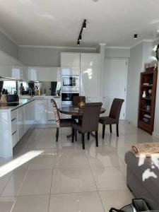 Una cocina y un comedor con mesa y sillas. en Your Oasis in Waterfall City, en Midrand 4 fotos más