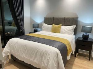 Un dormitorio con una cama grande y dos lámparas sobre mesas. en Your Oasis in Waterfall City, en Midrand