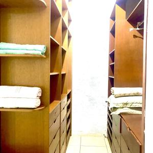 une salle de bain avec un placard avec des serviettes sur des étagères dans l'établissement Casa confortável e espaçosa em Búzios, à Armacao dos Buzios