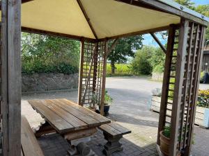 a wooden picnic table with an umbrella at Ferienwohnung Isi-Blick in Osterby