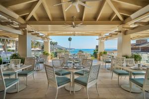 a dining room with tables and chairs and the ocean at Montage Laguna Beach in Laguna Beach