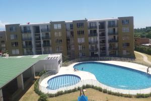 a large swimming pool in front of a building at Casa Río Apartamento con Aire Acondicionado y piscina in Valledupar