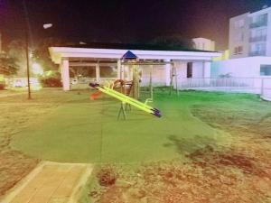 a park with a playground with yellow play equipment at Casa Río Apartamento con Aire Acondicionado y piscina in Valledupar
