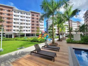 a patio with chairs and a pool in a building at Auberge Condotels at SMDC Hope Residences in Trece Martires