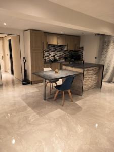 a kitchen with a table and a chair in a room at Maison cosy 2 chambres proche Troyes in Villacerf