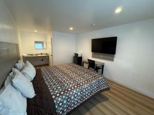 a bedroom with a bed and a flat screen tv at Sun Leisure Motel in Menifee