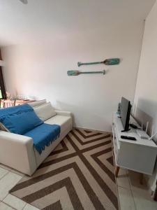 a bedroom with a bed and a desk with a computer at Praia Enseada Apartamento entre Praias in Ubatuba