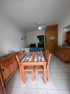a kitchen with a wooden table with four chairs at Praia Enseada Apartamento entre Praias in Ubatuba