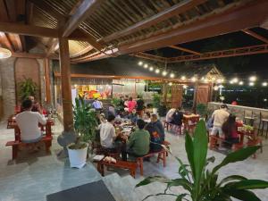 a group of people sitting at tables in a restaurant at Mèo Vạc Beehive House in Mèo Vạc