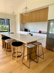 a kitchen with a large island with bar stools at Alpine Abode in Wanaka +18 photos