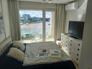 a bedroom with a bed and a window with a view at Apart , DEPARTAMENTO CONDOMINIO BAHIA GRANDE NORDELTA, TIGRE , BALCÓN Y VISTA A LA Bahia in Buenos Aires