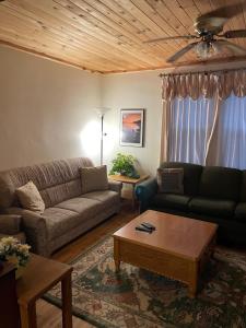 a living room with a couch and a coffee table at 4 Bedroom Cottage on Manitoulin Island Next to Sand Beaches! in Providence Bay
