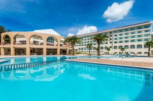 a hotel with a large swimming pool in front of a building at Mira Serra Parque Hotel in Passa Quatro