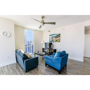 a living room with two blue chairs and a table at 2BR Uptown Charlotte Furnished Apartments apts in Charlotte