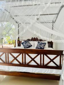 Cette chambre comprend un lit à baldaquin. dans l'établissement VOGEL NEST, à Midigama-Est