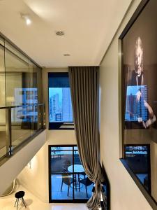 a living room with a large window and a tv at Premier Apartment - Hotel Mercure Belém Boulevard in Belém