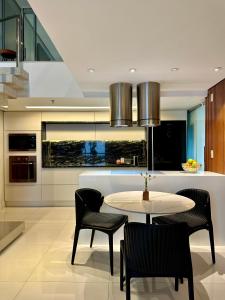 a dining room with a table and chairs in a kitchen at Premier Apartment - Hotel Mercure Belém Boulevard in Belém