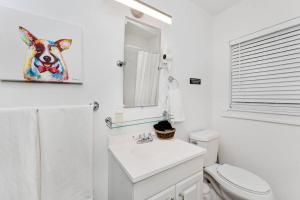a bathroom with a toilet and a painting of a cow at Relaxing 3-Bedroom With 150 Inch Projector & Pool Table in Jacksonville +7 photos