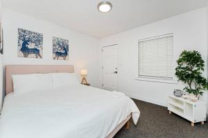 a white bedroom with a bed and a window at Relaxing 3-Bedroom With 150 Inch Projector & Pool Table in Jacksonville