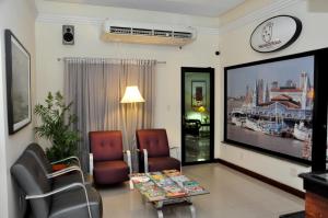 a living room with two chairs and a flat screen tv at Machado´s Plaza Hotel in Belém