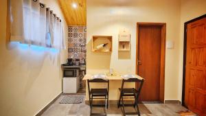 a small kitchen with a table and two chairs at Chalé Sunset in Miguel Pereira