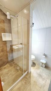 um banheiro com box de vidro e vaso sanitário em Chalé Sunset em Miguel Pereira