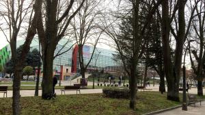 a group of trees in a park with a building at Hostal Lar in Burgos