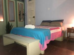 a bed with a bench in a room at Monoambiente Alojamiento Central in Tarija